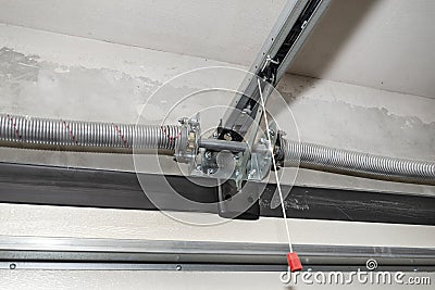 Springs tensioning the home garage door mechanism, view from the inside, visible rail with chain. Stock Photo