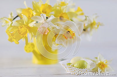 Springtime daffodils in full bloom and Easter eggs on white wooden table Stock Photo