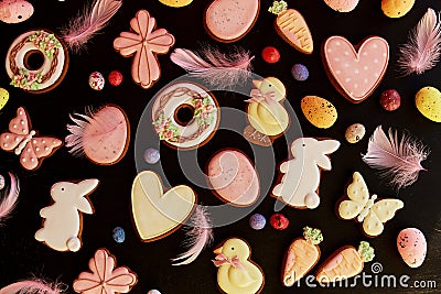 Springtime Easter aesthetics glazed cookies decorated feathers on black background. Happy Easter banner Stock Photo