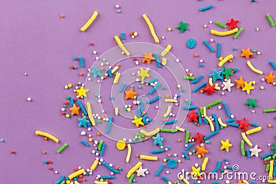 Sprinkle background with rainbow sprinkle shapes, stars, stripes, little balls on lilac background Stock Photo