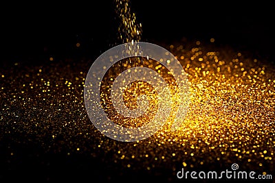 Sprinkle gold glitter dust on a black background Stock Photo