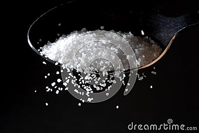 A sprinkle of salt from a spoon Stock Photo