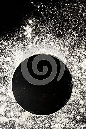 Sprinkled wheat flour circle, round spot on black. Top view on blackboard. Baking concept, cooking dough or pastry Stock Photo