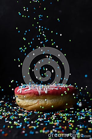 Sprinkles falling onto donut Stock Photo
