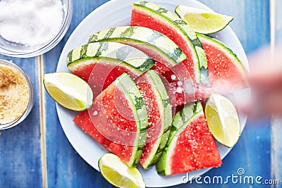 Sprinkling salt on pile of watermelon slices Stock Photo