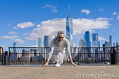 Sprinter leaving starting on running track outdoor. Runner on start. Athlete man ready in running start in New York city Stock Photo