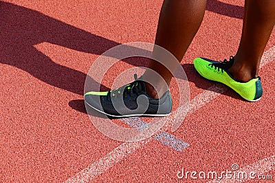 Sprinters feet wearing runners shoes standing on an athletics track Stock Photo