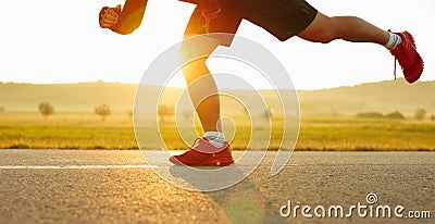 Sprinting man runner sprinter athlete running shoes and legs on track and field lane run race competing fast panoramic Stock Photo
