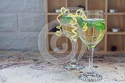 Spritzer cocktail with white wine, mint and ice, decorated with spiral lemon zest, copy space Stock Photo