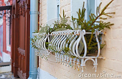 Spruce branches adorn the windowsills of windows outside. Christmas decorations of the old city street Stock Photo