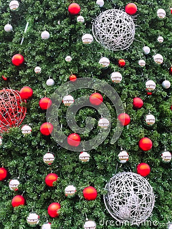 Spruce branches with many small red and silver balls and three large braided balls. Stock Photo