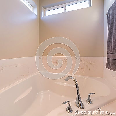 Square Alcove bathtub with widespread stainless steel faucet Stock Photo