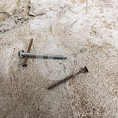 Square background with rusty screws on concrete surface Stock Photo