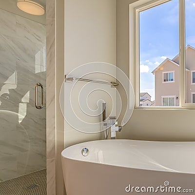 Square Bathtub and separate shower inside the bathroom of a new home Stock Photo