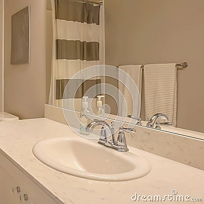 Square Bathtub and shower with a striped curtain inside a small bathroom Stock Photo