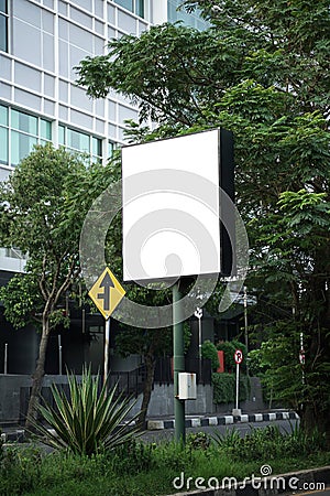 Square billboard with a backdrop of trees and buildings Stock Photo