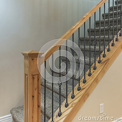 Square Carpeted stairs with wooden handrailing and wrought iron baluster Stock Photo