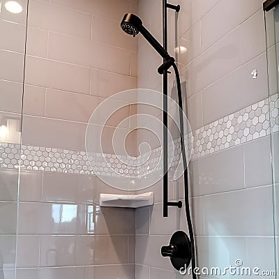 Square crop Black round shower head on tile wall of shower stall with hinged glass door Stock Photo