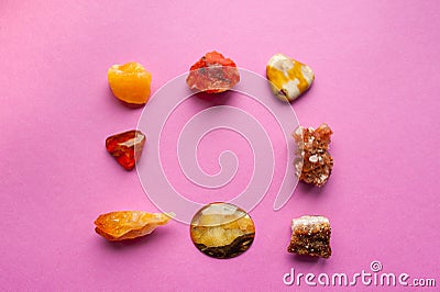 A square of different minerals on pink background. Spiritual amber, calcite, Aragonite, Simbercite, Jasper, Tiger`s eye Stock Photo