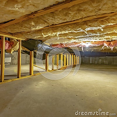 Square frame Basement or crawl space with upper floor insulation and wooden support beams Stock Photo