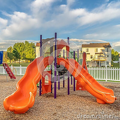 Square frame Bright orange and blue slides at a colorful fun playground for children Stock Photo