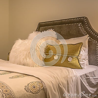 Square frame Double bed with fluffy pillows against the upholstered belgrave headboard Stock Photo
