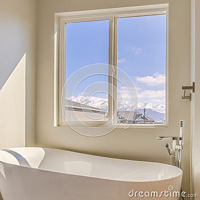 Square frame Glossy bathtub and separate shower inside the sunlit bathroom of a new house Stock Photo