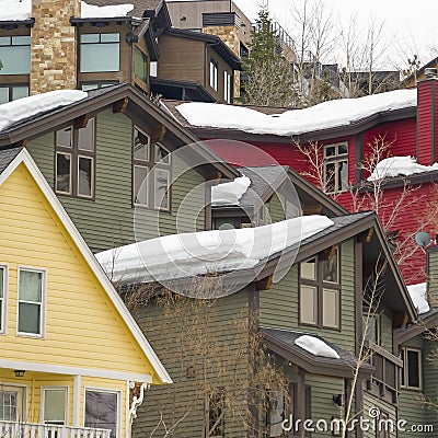 Square frame Home exteriors with horizontal wall siding and thick snow on the roofs Stock Photo