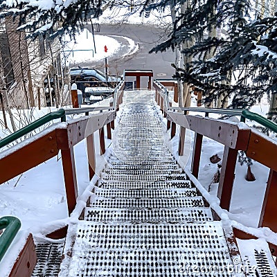 Square frame Stairway and road on snow covered hill amid houses and coniferous trees Stock Photo