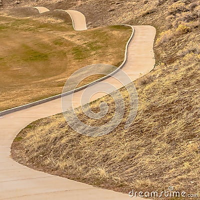 Square frame Winding narrow rural road through foothills Stock Photo