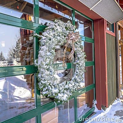 Square Frosted wreath on the glass wall of building that reflects the winter landscape Stock Photo