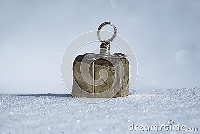 Square gold stone mineral Pyrite against a background of light snow close up Stock Photo