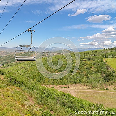 Square Hiking trails and vibrant foliage under chairlifts and blue sky at off season Stock Photo