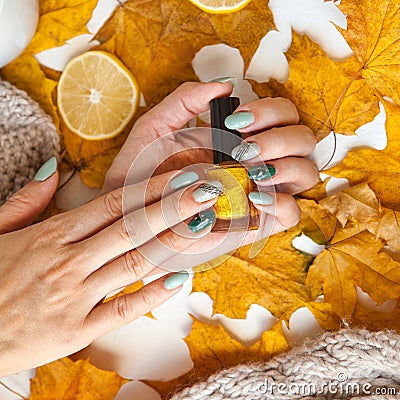 square image of manicure on green and grey nails with black and gold rhinestones with brilliant ornament on hand. golden Stock Photo