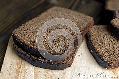 Square loaf of black rye bread Cut into pieces Stock Photo