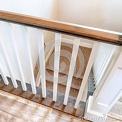 Square Looking down on U shaped indoor staircase with white baluster and brown handrail Stock Photo
