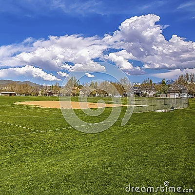 Square Panorama of a soccer field with houses and mountain in the distance Stock Photo