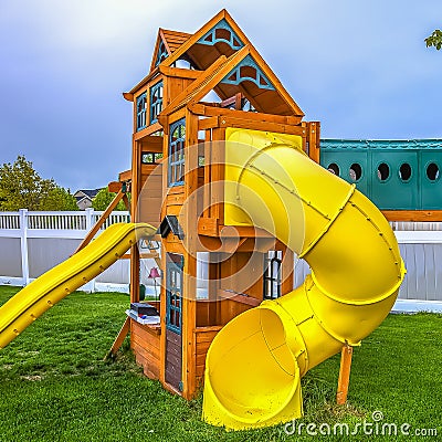 Square Playground at the backyard of a home inside a white wooden fence. Stock Photo
