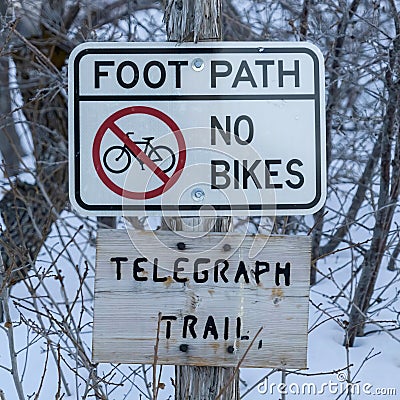 Square Signages by a foot path trail at Wasatch Mountains blanketed with snow in winter Stock Photo