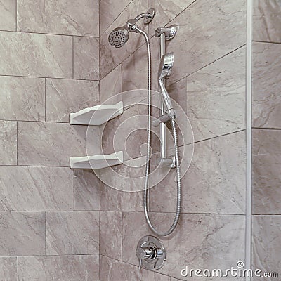 Square Square bathtub and stainless steel shower against gray and white tile wall Stock Photo