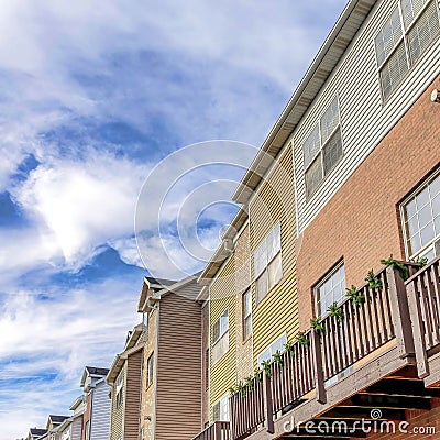 Square Townhouses with balconies over garages against Wasatch mountain and cloudy sky Stock Photo