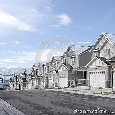 Square Townhouses on a scenic subrban landscape against lake mountain and cloudy sky Stock Photo