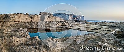 Square water reservoir on the rocky sea coast, Gozo. Stock Photo