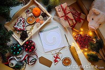 A square white notebook on a white background surrounded by pigs and Christmas and New Year trifles Stock Photo