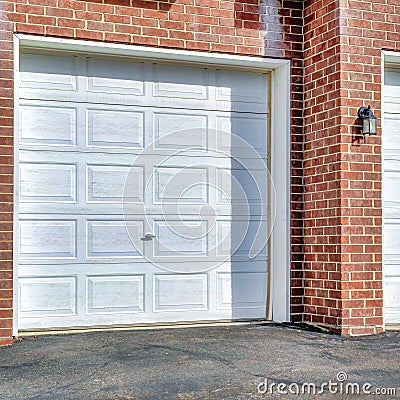 Square White panelled garage doors of townhouses in the neighborhood on a sunny day Stock Photo