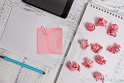 Squared open spiral notebook marker sticky note clip smartphone paper balls lying wooden retro vintage rustic old Stock Photo