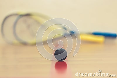 Squash ball on court with two squash rockets ready to play Stock Photo