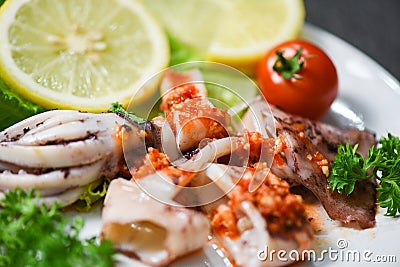 Squid salad with chilli sauce spicy herbs and spices Grilled squid slice on plate in the seafood restaurant Stock Photo