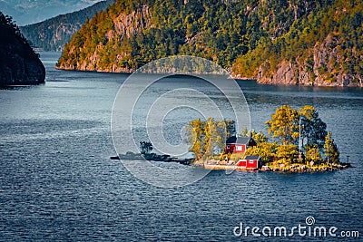 Sramatic summer view with small island with typical Norwegian building with red wall on Lovrafjorden flord Stock Photo