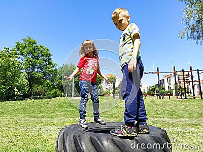 Sremska Mitrovica, Serbia, June 6, 2020. Children jump on the tire from the wheel. A boy and a girl stand on a rubber tire and try Editorial Stock Photo